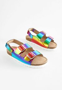 Regnbågsfärgade sandaler med tre justerbara remmar, glänsande metallisk finish, korkfot och vit gummisula för extra komfort.