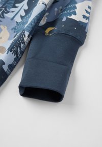 Børns zip-up jakke med mønstret stof i blå nuancer og dyrelivsmotiver; ribbede marineblå manchetter for en sikker pasform.