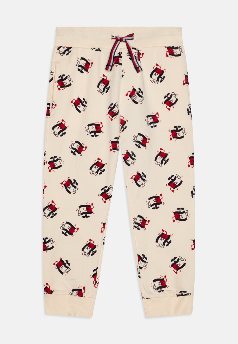Beige sweatpants with a repeated cartoon pattern featuring characters in red and black. Elastic waistband with drawstring and ribbed cuffs.