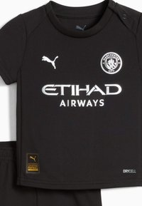 Czarny strój piłkarski z koszulką z krótkim rękawem z logo Pumy, herbem Manchester City oraz napisem "ETIHAD AIRWAYS" w białym kolorze. Zawiera szorty.