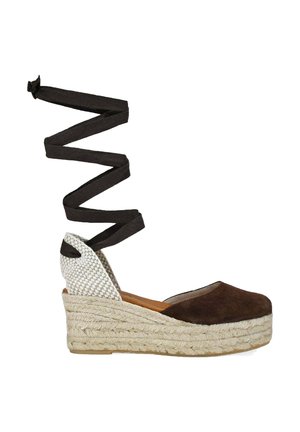 Alpargata cuña de ante marrón con suela de yute trenzado, puntera cerrada, contrafuerte tejido en el talón y largas cintas negras para atar al tobillo.