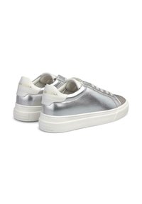 Metallisch schimmernde silberne Sneakers mit weißen Akzenten, glatter Textur, abgerundeter Spitze und einer flachen Gummisohle, die ein dezentes Logo auf der Ferse trägt.