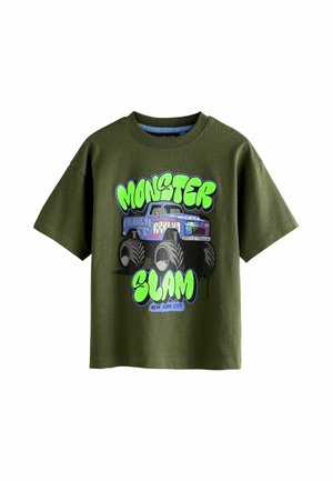 Green cotton t-shirt with a loose fit, featuring a colorful graphic of a monster truck and stylized text reading "MONSTER SLAM NEW YORK CITY."