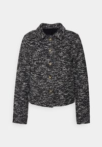 Schwarz-weiße gepunktete Jacke mit Kragen, Knopfverschluss und langen Ärmeln, aus gewebtem Stoff mit strukturierter Optik.