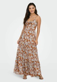 Maxikjole i brunt med blomsterprint i blå og creme. Har en cowl neck, justerbare stropper og lagdelt flæse-design.