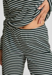 Groene en witte gestreepte lounge set met een losse top en broeken met elastische tailleband, gemaakt van zachte, lichte stof.