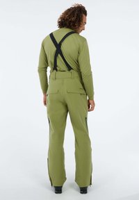 Groene waterdichte skibroek met verstelbare zwarte bretels, zijritsen voor ventilatie en twee achterzakken. Gladde, duurzame stof.