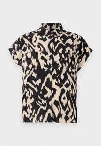 Chemise à manches courtes en crème et noir, avec un motif léopard, un bouton à l'avant et deux poches poitrine. Texture de tissu lisse.