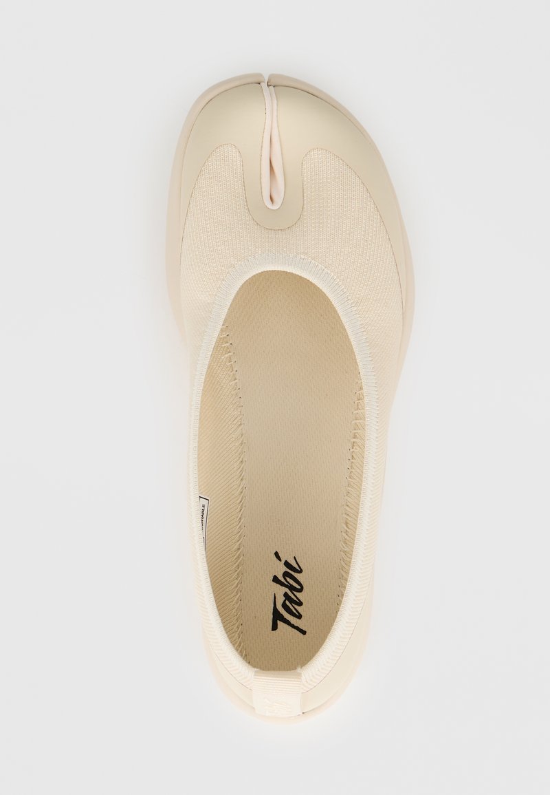 Μπεζ παπούτσι τύπου slip-on με σχεδιασμό διαχωρισμένου δακτύλου, πλεκτό επάνω μέρος και λείο πέλμα, σε προβολή από πάνω με το λογότυπο "Tabi" εσωτερικά.