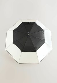 Schwarz-weißer achteckiger Regenschirm mit glatter Stoffoberfläche und einem metallischen Griff in der Mitte, der ein kontrastierendes Paneeldesign aufweist.