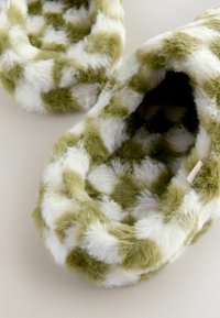 Fuzzy slippers featuring an alternating green and white checkered pattern, with a soft texture and rounded shape.