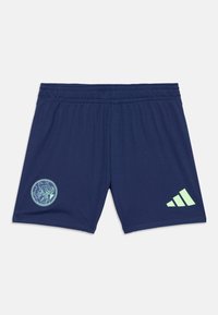 Tamsiai mėlynos sportinės šortai su elastinga juosmens juosta, turintys mėtų žalumos spalvos apvalų logotipą ir tris dryžuotas akcentus dešinėje pusėje.