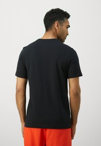 Black short-sleeve t-shirt made of cotton, featuring a classic crew neckline and a soft texture. Smooth fabric with no visible patterns.