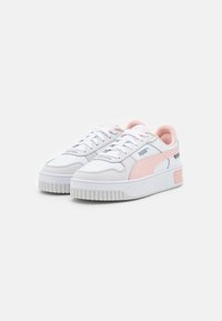Bílé kožené tenisky s růžovým akcentem, kulatá špička, silná bílá gumová podešev a perforovaná detaile na svršku. Zobrazeno logo Puma.