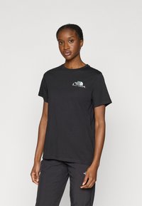 Μαύρο βαμβακερό t-shirt με κοντά μανίκια, που διαθέτει μικρό λογότυπο στο στήθος. Ομαλή υφή και τυπικός σχεδιασμός με στρογγυλή λαιμόκοψη.