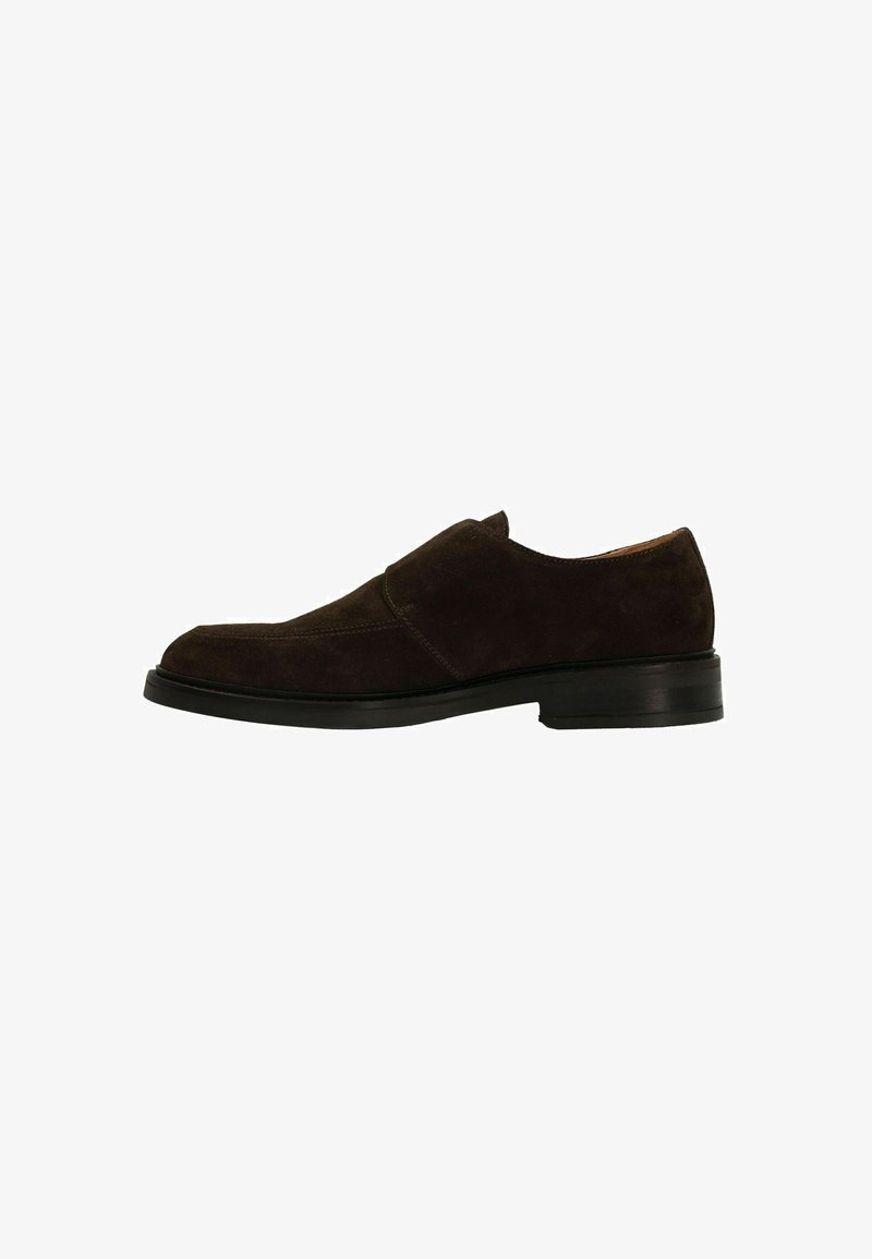 Brown suede slip-on shoe with a rounded toe, low stacked heel, and minimal seam detailing. The texture is soft and matte.