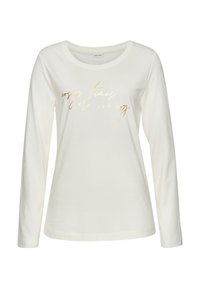Long-sleeve cream t-shirt made of soft fabric, featuring a gold metallic printed phrase "cosy times are coming" on the front.
