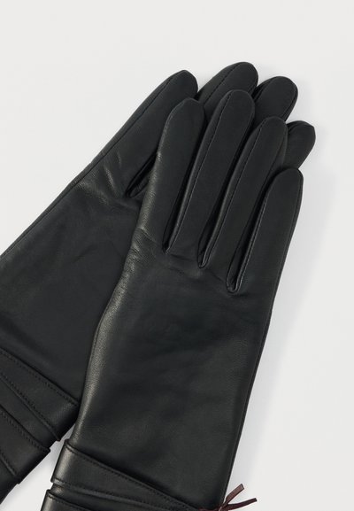 Fekete bőr kesztyűk, sima felülettel, testhezálló kialakítással és a csuklónál gyűrt részletekkel. Öt ujj, varrással a varratok mentén.