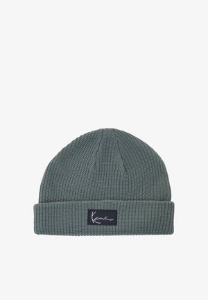 Szürke kötött sapka behajtott szegéllyel és elöl fehér dőlt betűs szöveget tartalmazó fekete téglalap alakú címkével.