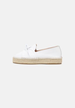 Hvide læder espadriller med en knyttet overdel, jute reb sål og en flad, affaset tå. Glat tekstur og minimalistisk design.