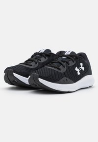 Scarpe da ginnastica nere con tomaia in rete, punta rotonda e suola intermedia bianca. Presentano lacci neri e un logo bianco ben visibile di lato.