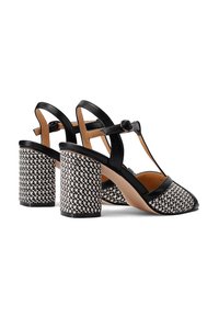 Le sandali con tacco neri e beige presentano un design a T, una trama a scacchi tessuta sul tacco e una parte superiore in pelle liscia.