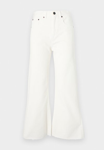 Bela denim jeans z razširjenimi hlačnicami in visokim pasom, petimi žepi ter surovim hemom. Značilni so kovinski dodatki in zapiranje na gumb.