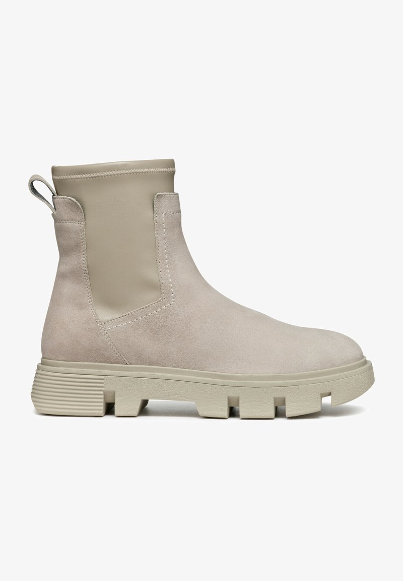 Bottine beige en daim avec un panneau beige lisse, une languette à l'arrière et une semelle épaisse et rainurée pour plus d'adhérence.