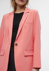 Pink blazer made of smooth fabric, featuring a single button closure, two front pockets, and a notch lapel design.