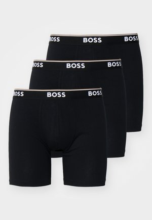 Bóxer negros en un paquete de tres. Material de algodón suave con un diseño ajustado. Cada uno cuenta con una cinturilla de logo en contraste.
