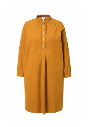 Vestido de pana mostaza con cuello tipo camisero, mangas largas, botón frontal y detalles de costura pin-tuck. Presenta un logo en el dobladillo.