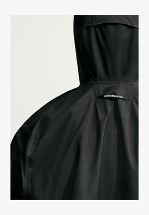 Black rain jacket with hood, showing back details and "All Conditions Gear" label on upper back.