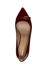 Décolleté in pelle vernice bordeaux con punta affusolata, cinturino alla caviglia e soletta imbottita con piccole perforazioni. Branding dorato visibile all'interno.