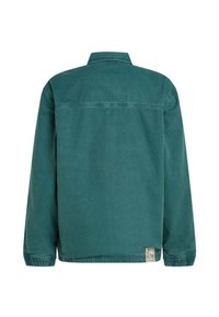 Zaļa kokvilnas jaka ar apkakli, garām piedurknēm un elastīgām aprocēm. Ir horizontāla šuve pāri mugurai un sānu etiķetes detaļa.