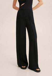 Zwarte wijde broek met een gladde textuur, voorzien van een hoge tailleband en scherpe plooidetails aan de voorkant.