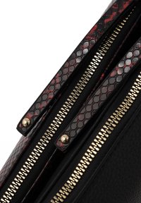 Borsa nera con accenti a serpente rosso e nero, dotata di due cerniere dorate con tiranti in metallo testurizzati. Superficie in pelle liscia.