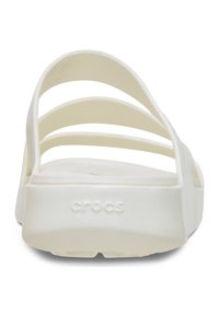 Witte Crocs-slippers met een gladde, glanzende afwerking, een open achterkant en meerdere horizontale banden. "CROCS" logo opgedrukt op de hiel.