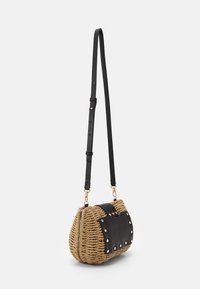 Tkaná slámová kabelka s černým koženým klopovým víkem, zlatými hřebíky a nastavitelným černým popruhem. Kulatý tvar s texturovaným povrchem.