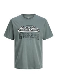 Camiseta de algodón verde con mangas cortas, con el texto gráfico "Jack & Jones" y la impresión "Superior Quality Denim Goods" en colores contrastantes.