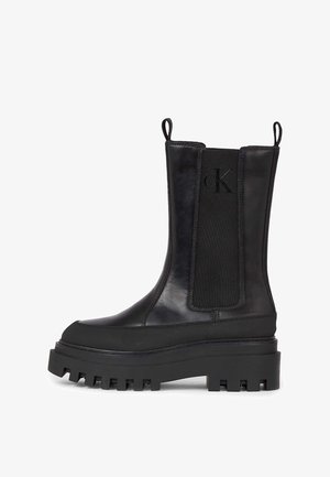 Zwarte leren enkellaarzen met elastische zijpanelen, dikke rubberen zolen en uittrek-lussen. Voorzien van een subtiel logo aan de zijkant.