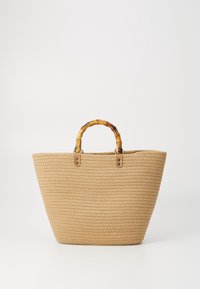 Woven straw tote bag in beige with a wide opening, bamboo handle, and metal accents. Sturdy design with textured surface.