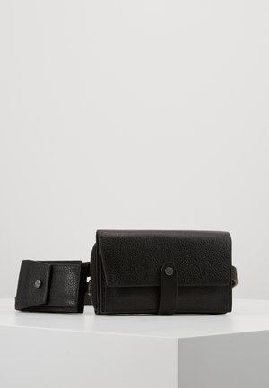 Sort struktureret læder crossbody taske med fold-over klap, magnetisk snap-lukning og aftagelig rem. Kompakt design til alsidig brug.