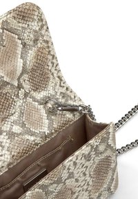Jasnobeżowa torebka ze wężowej skóry z srebrnym łańcuszkiem. Posiada zorganizowany kształt, teksturowane wnętrze oraz gładkie brązowe wykończenie wnętrza.
