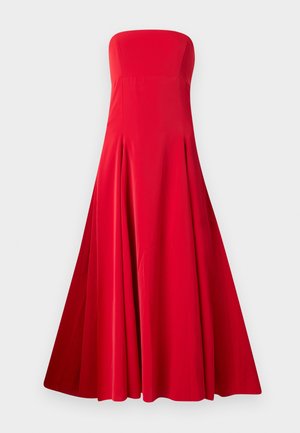 Robe rouge sans bretelles avec un corsage ajusté et une jupe large et fluide. Fabriquée en tissu lisse avec des plis pour le mouvement. Sans fermetures visibles.