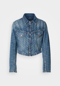 Veste en denim bleu avec fermeture éclair frontale, deux poches poitrine à rabat avec boutons, manches longues, et motifs discrets de lignes et d'écriture blanche.