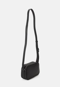 Borsa a tracolla nera in pelle con forma rettangolare, texture liscia e una lunga tracolla regolabile. Presenta una chiusura con zip.