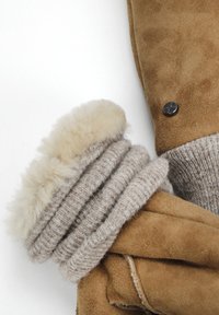 Suede rukavice světle hnědé barvy s béžovým pleteným manžetou a plyšovým kožíškem. Obsahují stříbrný knoflíkový detail na manžetě. Celkově měkká textura.