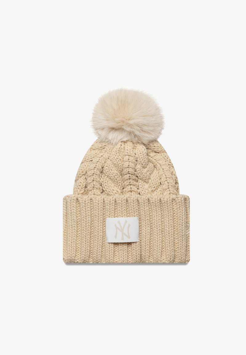 Gorro de malha em bege claro com um padrão de cabos, adornado com um pompom de pelúcia sintética, apresentando um patch de logotipo branco na dobra da aba.