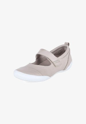 Zapato estilo Mary Jane color beige claro con suela de goma blanca y tira ajustable de velcro, mostrado en ángulo sobre fondo blanco.