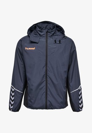 Laivastonsininen hupullinen tuulitakki, jossa koko etupuolen vetoketju, heijastavat vinot raidat hihoissa ja oranssi "hummel"-logo rinnassa.